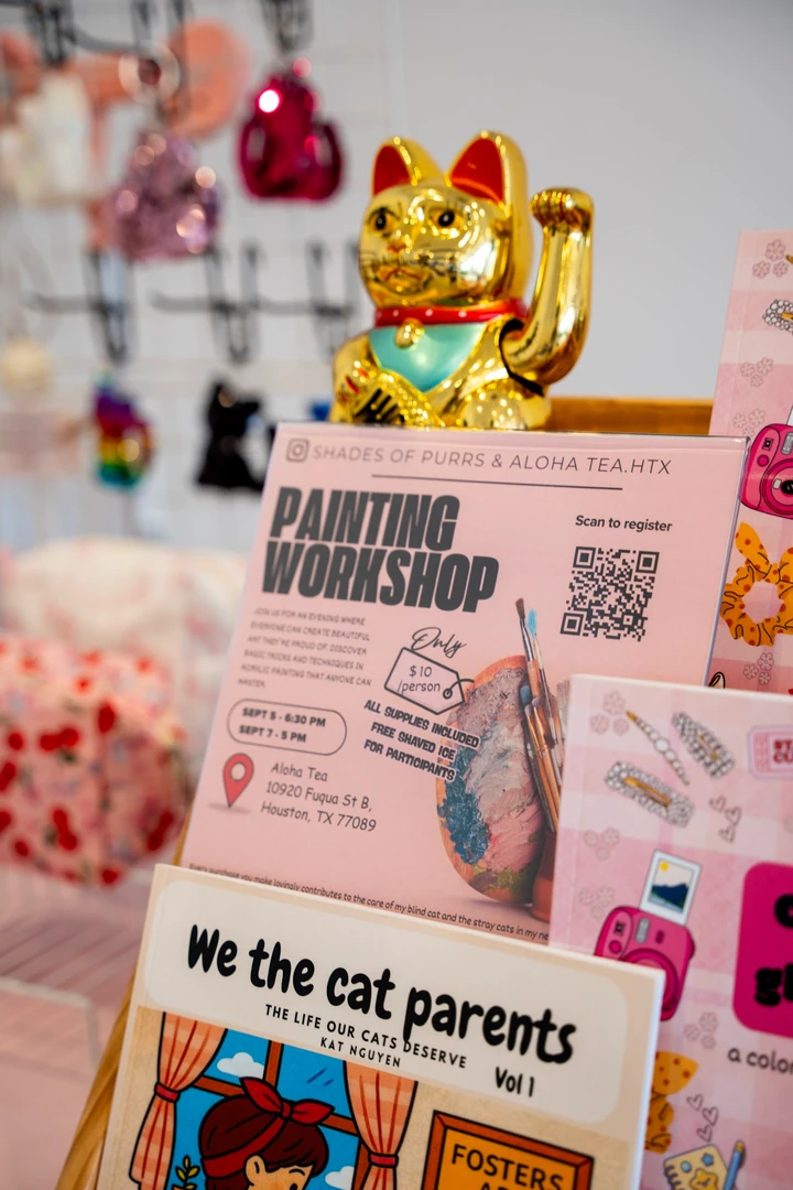 A golden waving cat beside a stall information card.