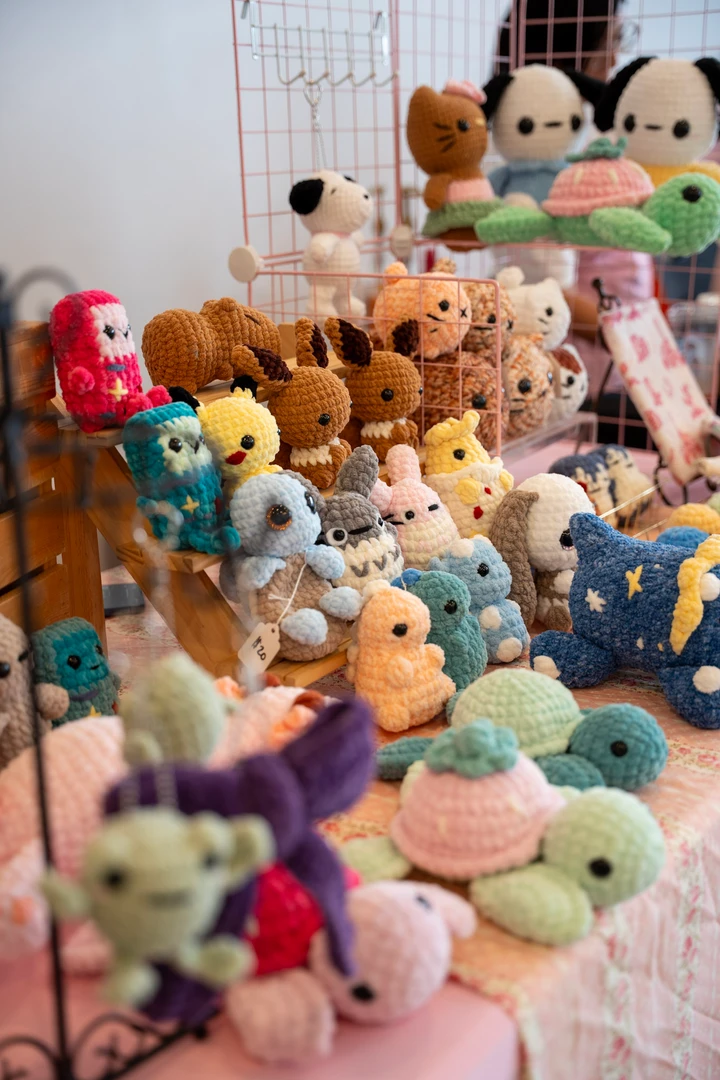 Colorful crocheted animals arranged across a craft table.
