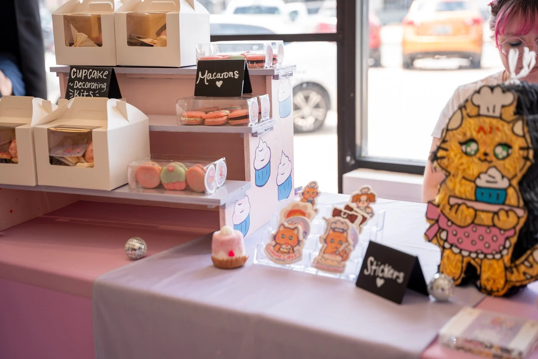 Macarons and small decorated treats on a market table.