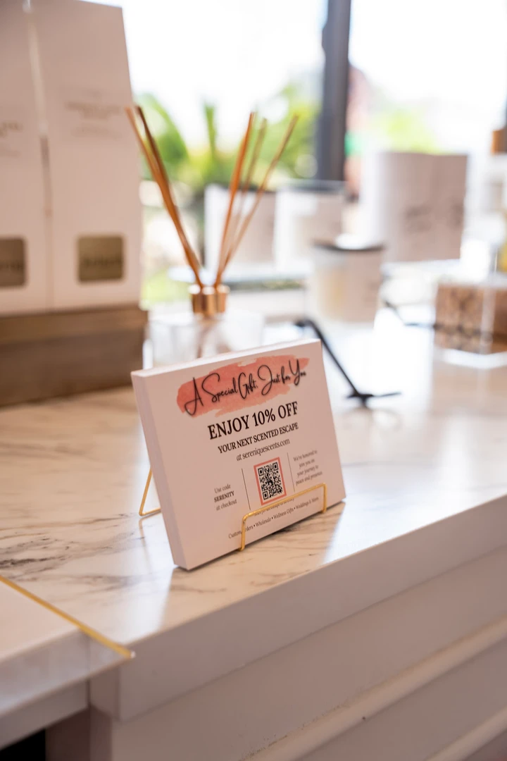 A reed diffuser and small display cards beside a window.
