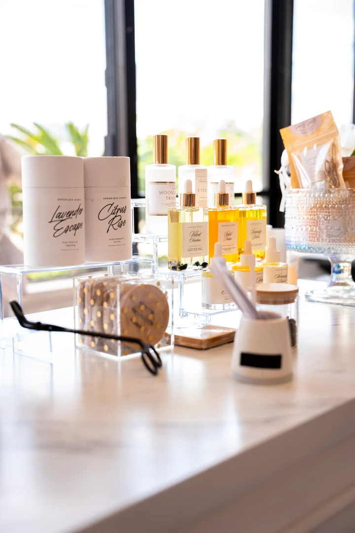 Bottles and jars of beauty products on a bright table.