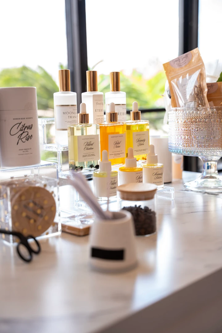 Bottles and jars of beauty products on a bright table.