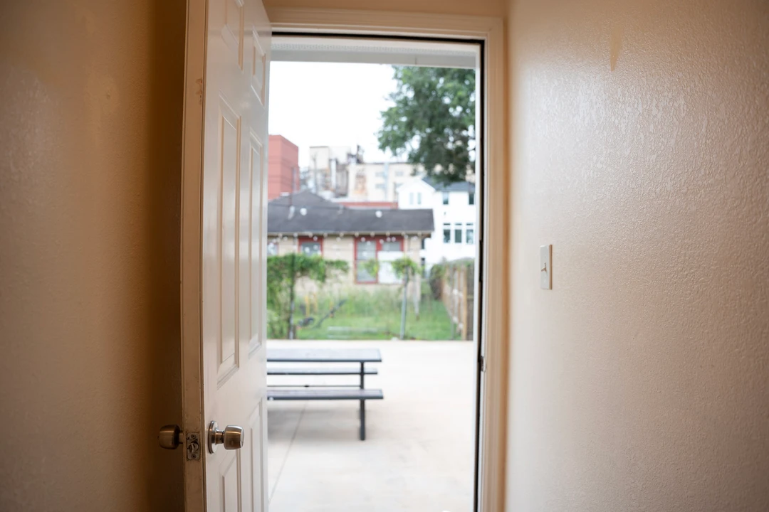 A doorway opens onto a patio with an outdoor table.