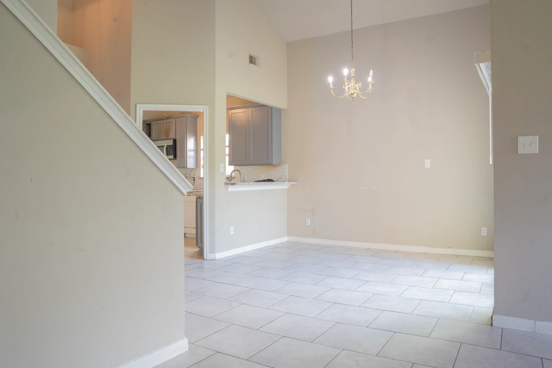 An open dining area with a chandelier and a view toward the kitchen.