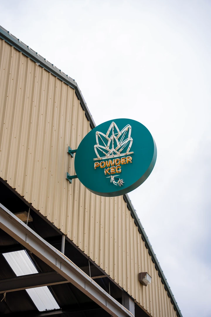 The Powder Keg sign above an outdoor market canopy.