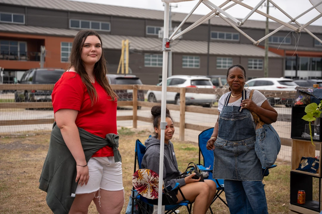 Friends gathering beside the outdoor market stalls.