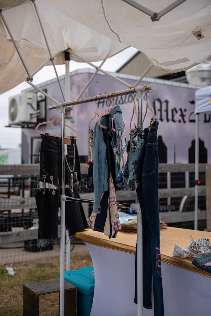 Jewelry and clothing displayed beneath a white market canopy.