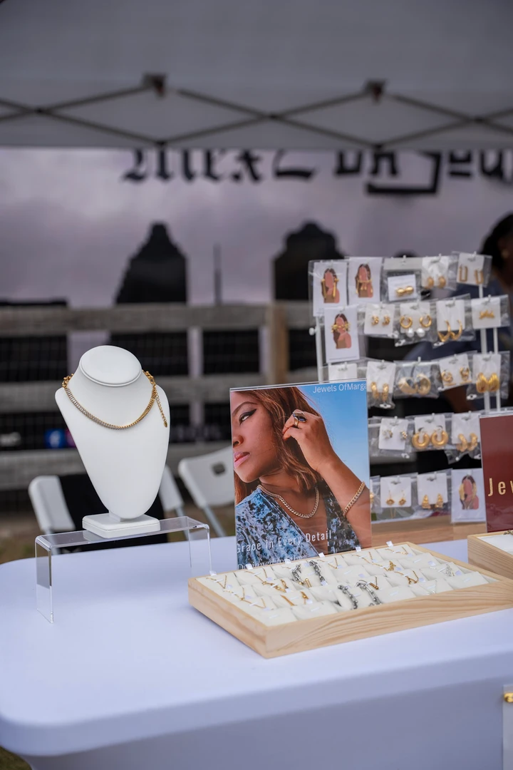 Jewelry and clothing displayed beneath a white market canopy.