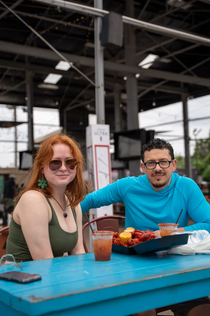 Market visitors sharing food at picnic tables.
