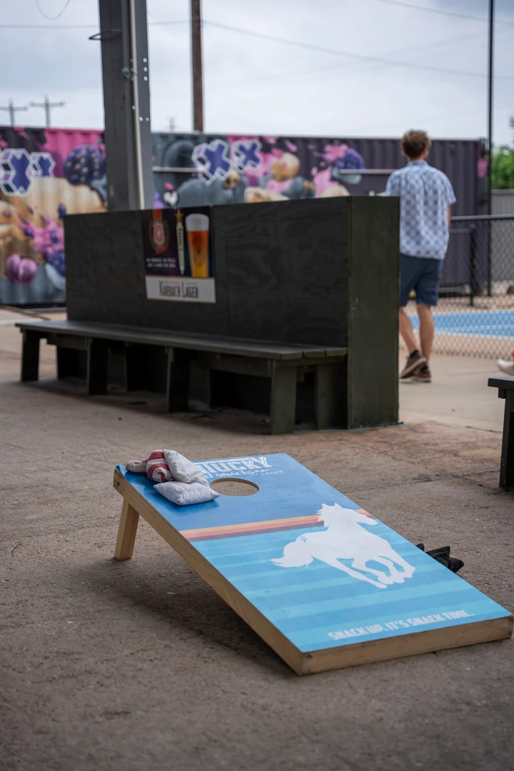 A cornhole board beside the covered seating area.
