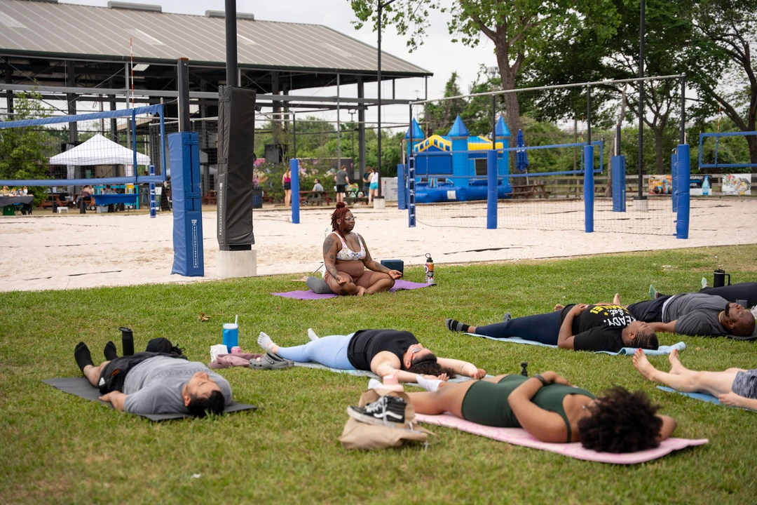 People practicing yoga together on a green lawn.