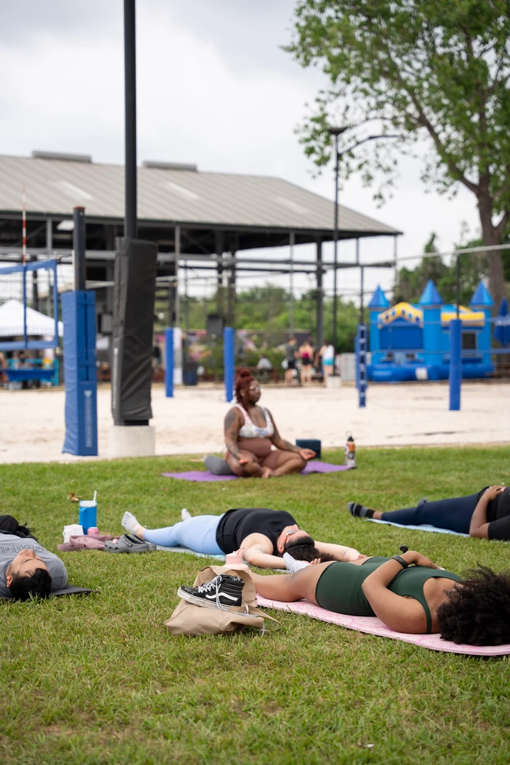 People practicing yoga together on a green lawn.