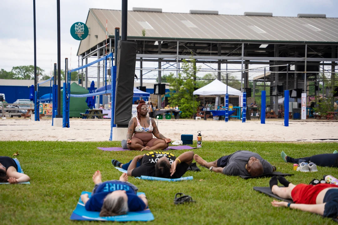 People practicing yoga together on a green lawn.