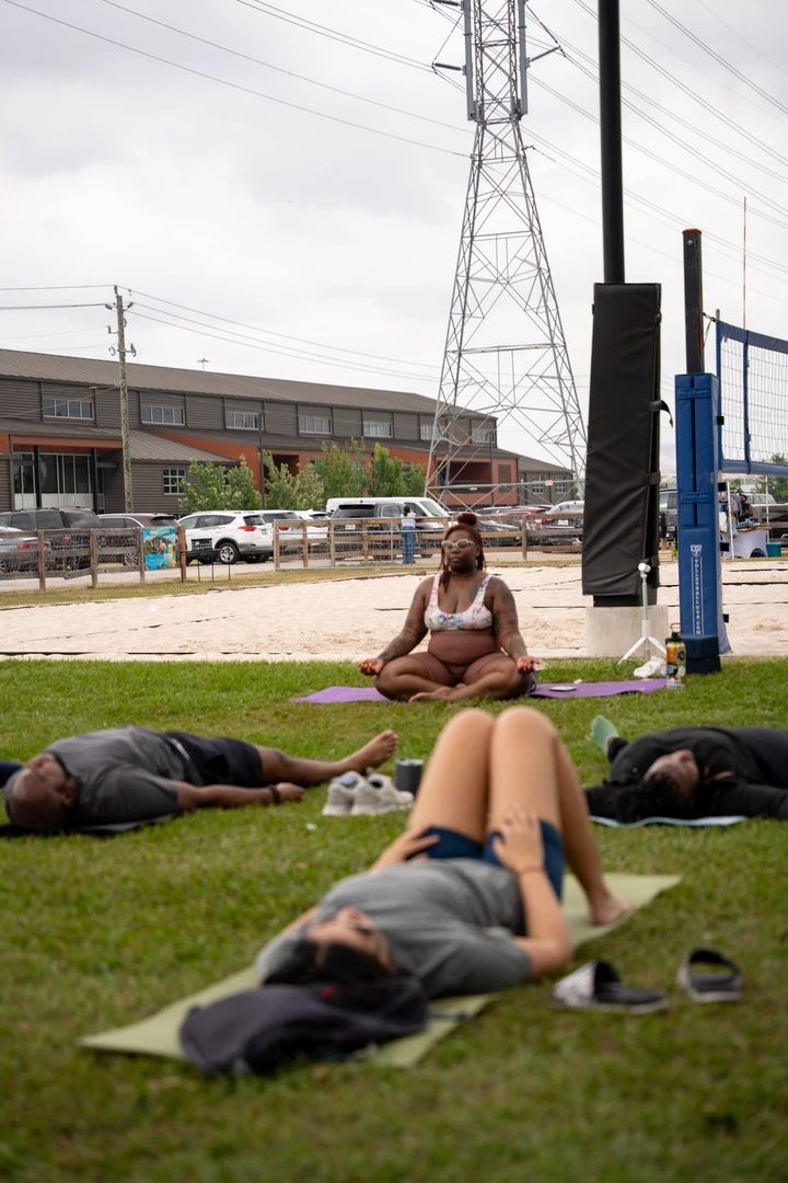 People practicing yoga together on a green lawn.