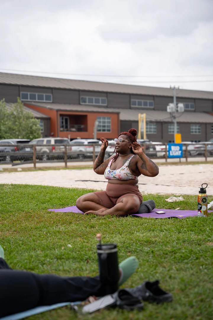 People practicing yoga together on a green lawn.