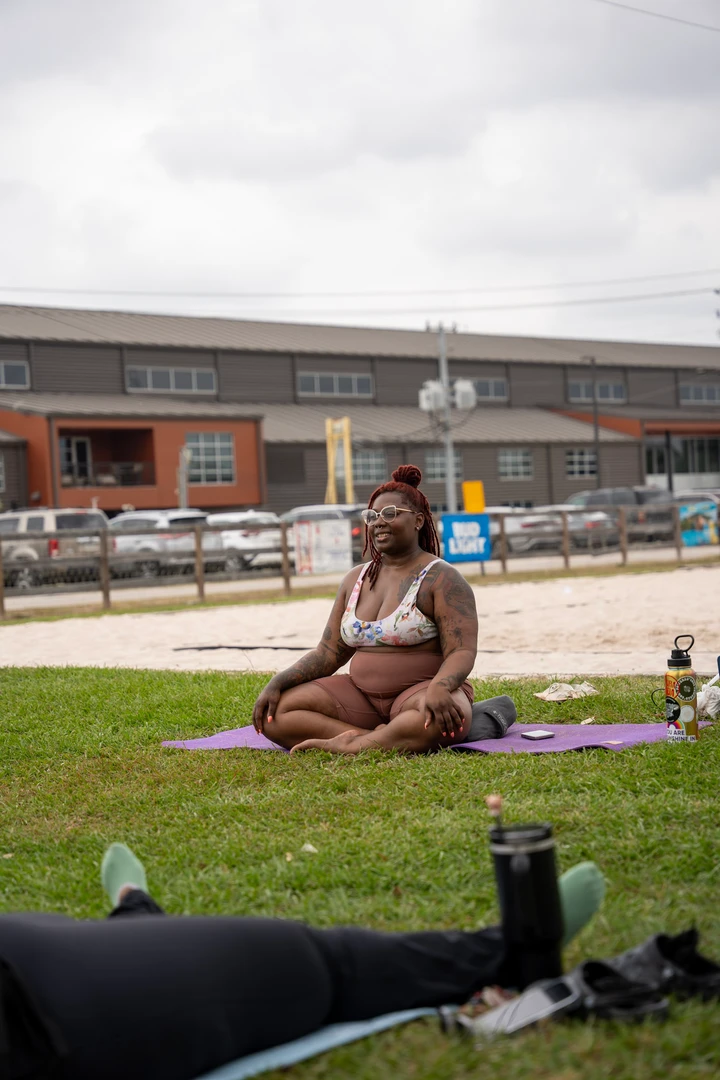 People practicing yoga together on a green lawn.