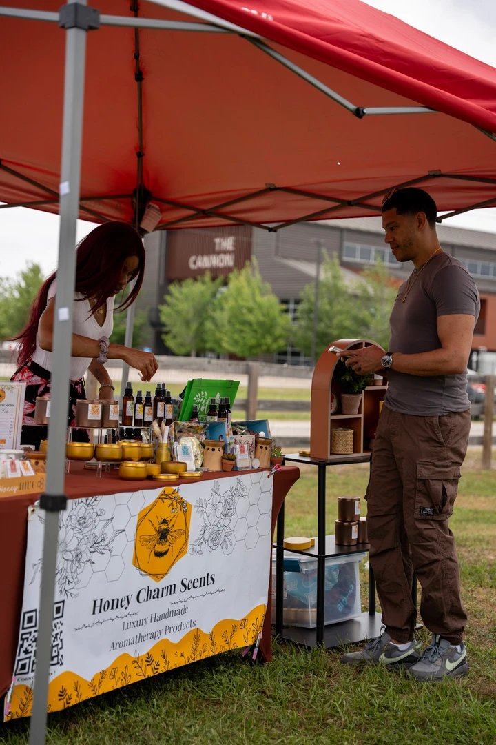 The Honey Charm Scents stall beneath a red canopy.