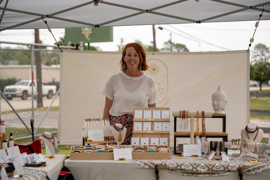 A maker in white standing behind a candle display.