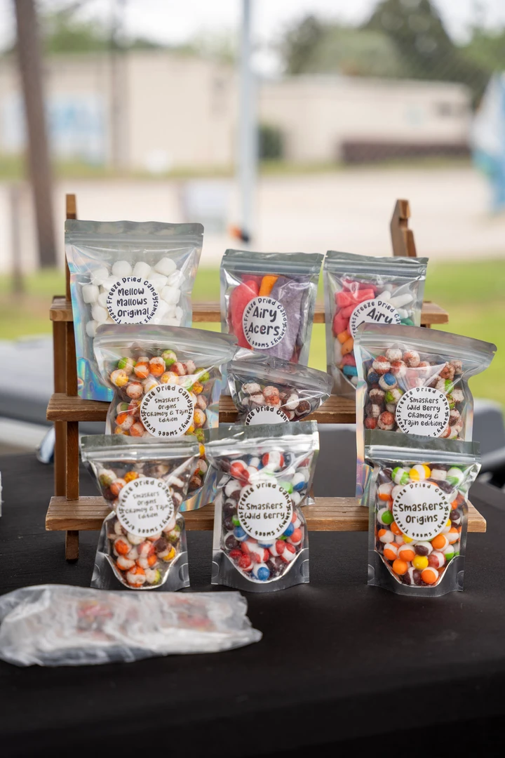 Bags and containers of colorful candy on a market table.