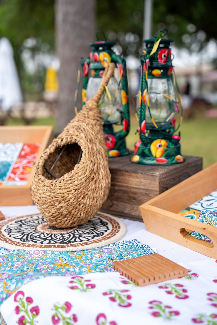 Woven and wooden birdhouses displayed beneath a market canopy.