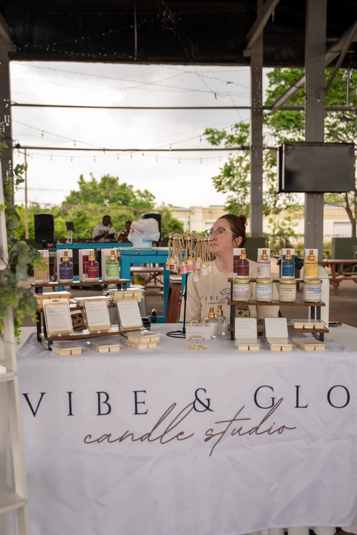Candles and greenery arranged at a Vibe and Glo market stall.