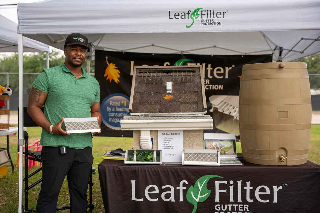A vendor in green at the LeafFilter demonstration booth.