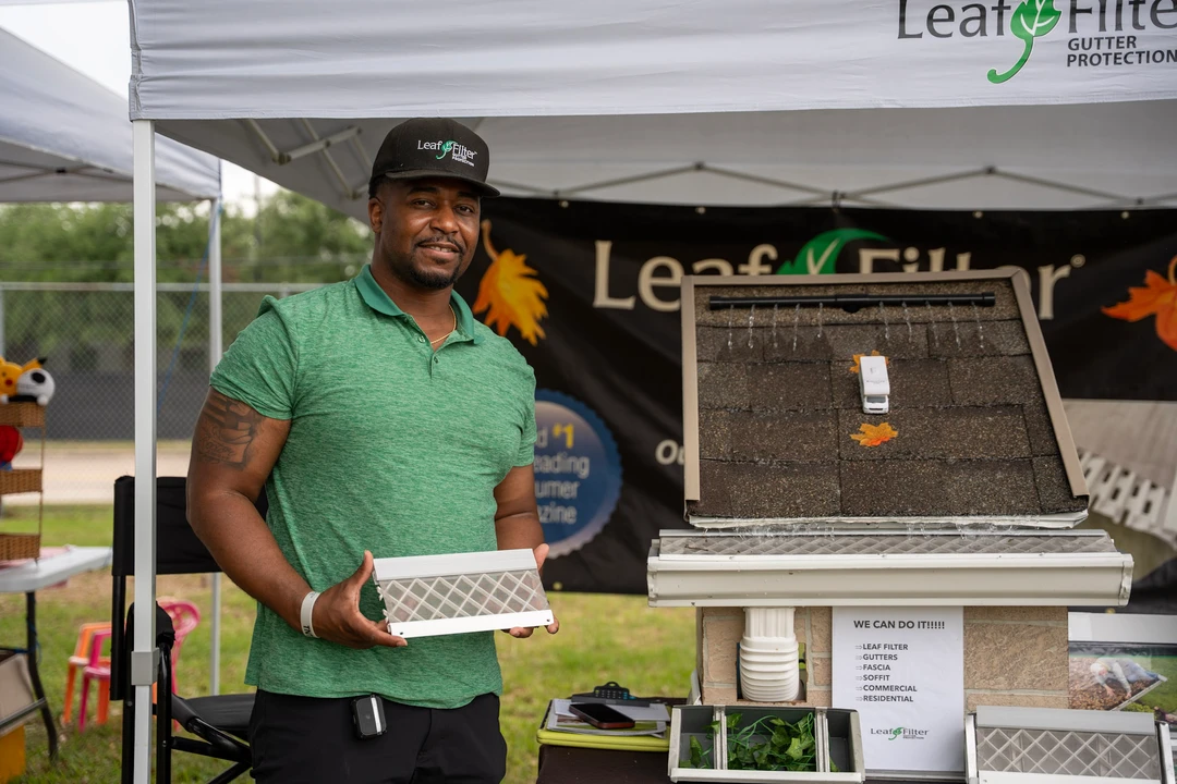 A vendor in green at the LeafFilter demonstration booth.