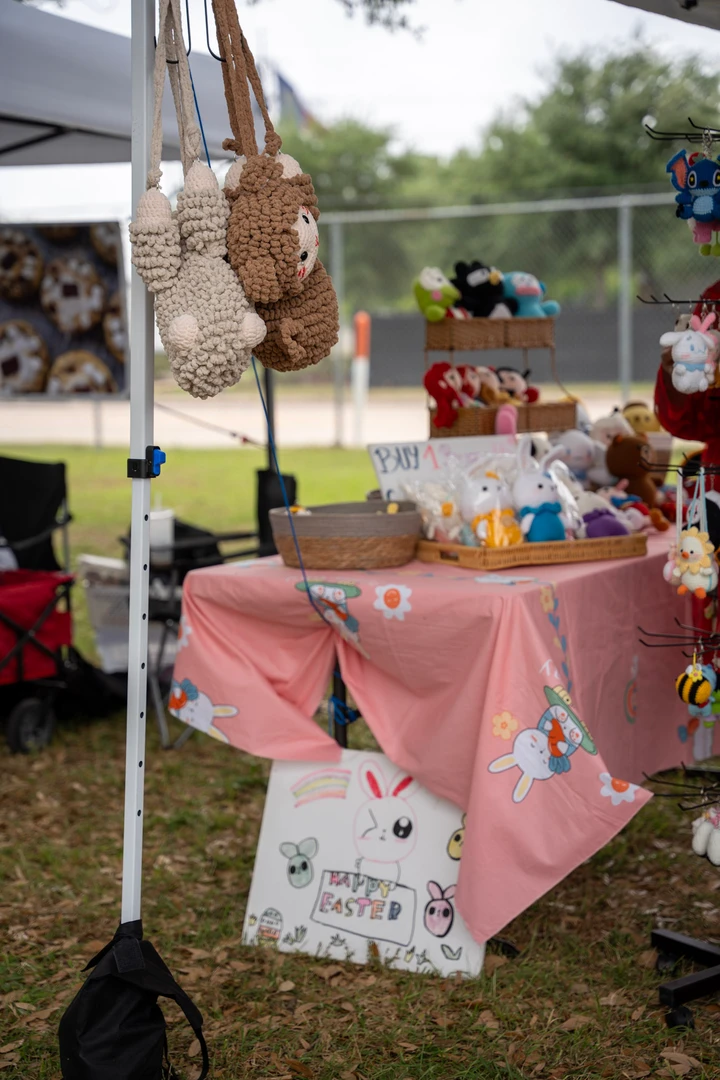 Crocheted animal bags hanging from a market canopy.