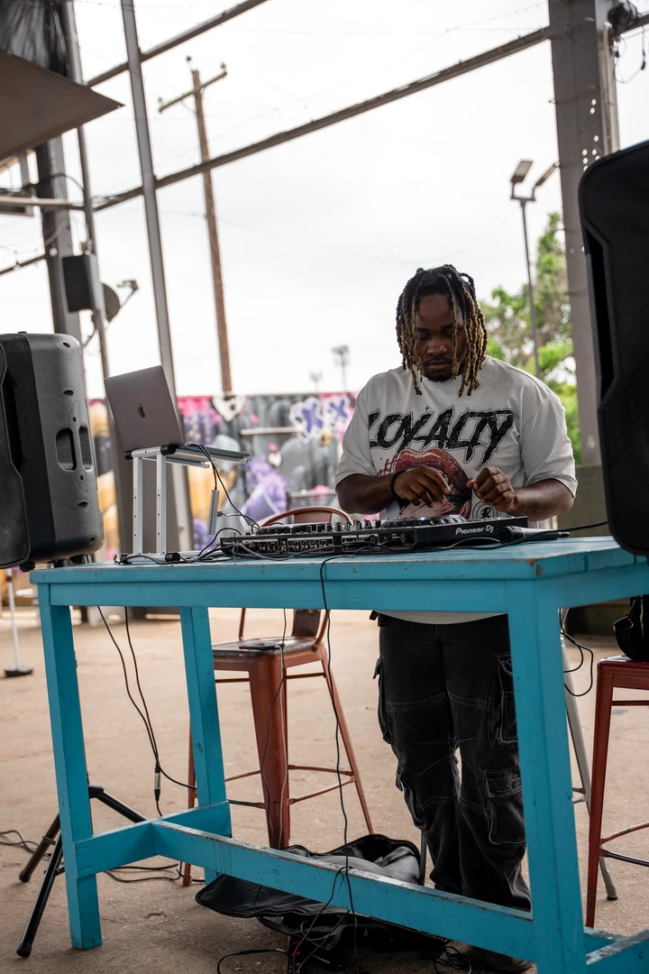 A vendor behind a display table beneath an outdoor canopy.