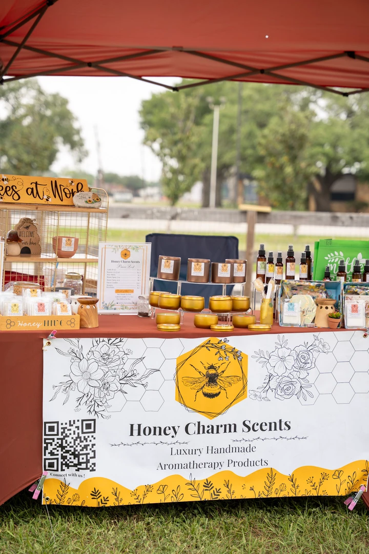 The Honey Charm Scents candle display beneath a red canopy.