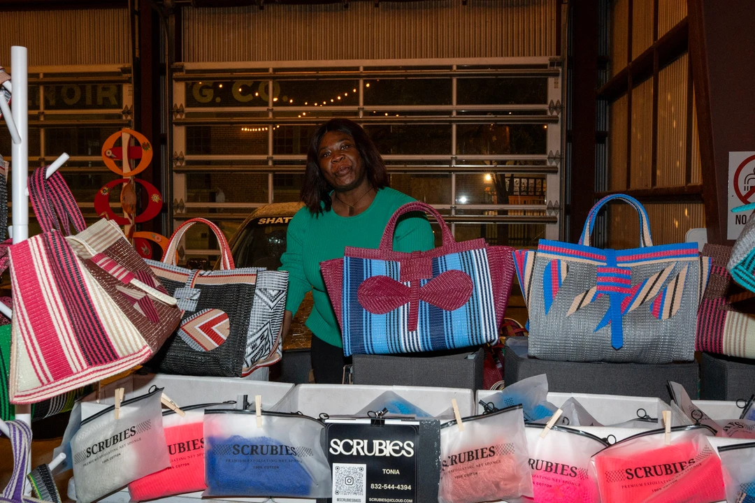 Colorful tote bags displayed at an indoor market stall.
