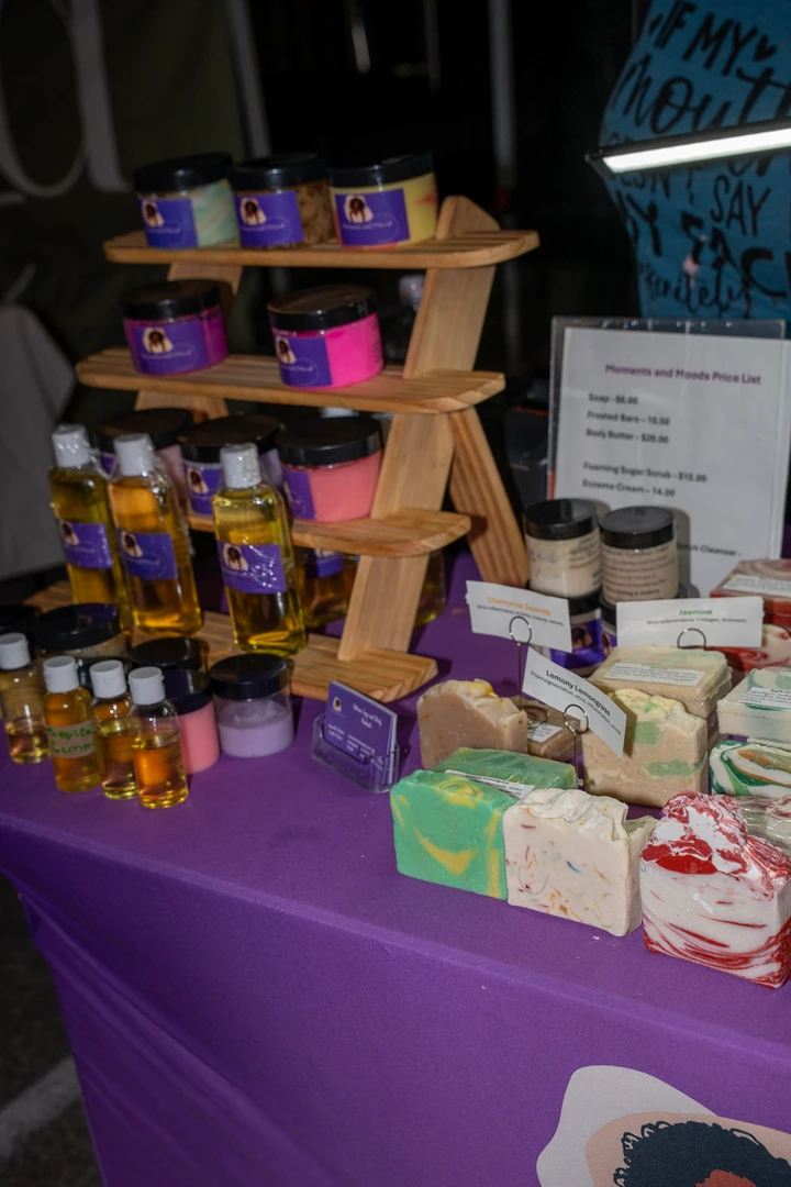 Soap and small gifts arranged on a purple-covered table.