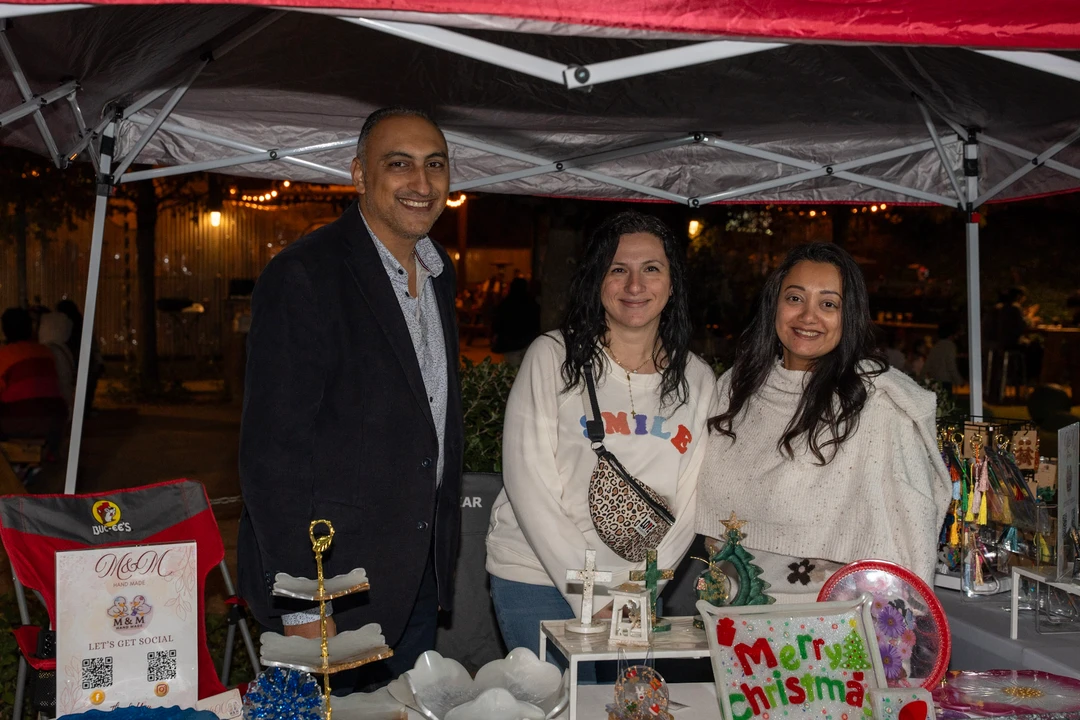 Three smiling makers behind a holiday gift display.