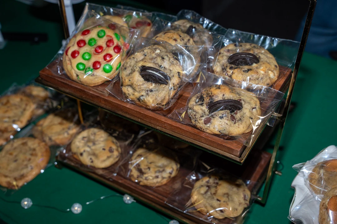 Decorated cookies displayed in trays on a green-covered table.