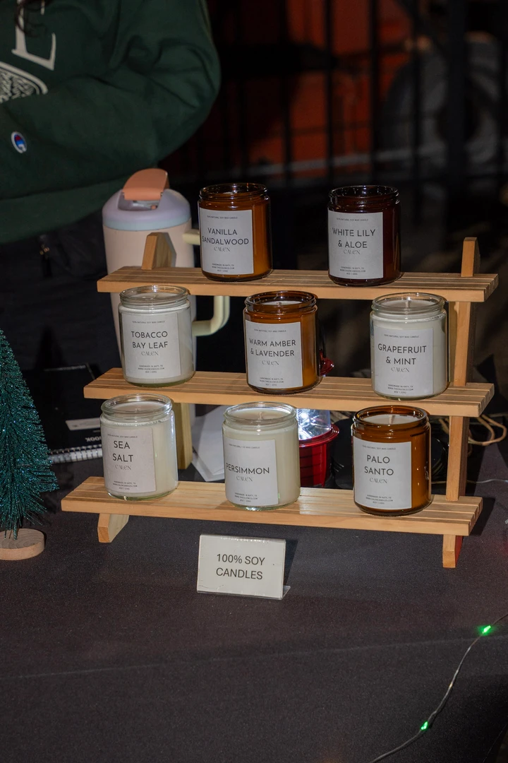 Candles and small festive decorations on wooden display shelves.