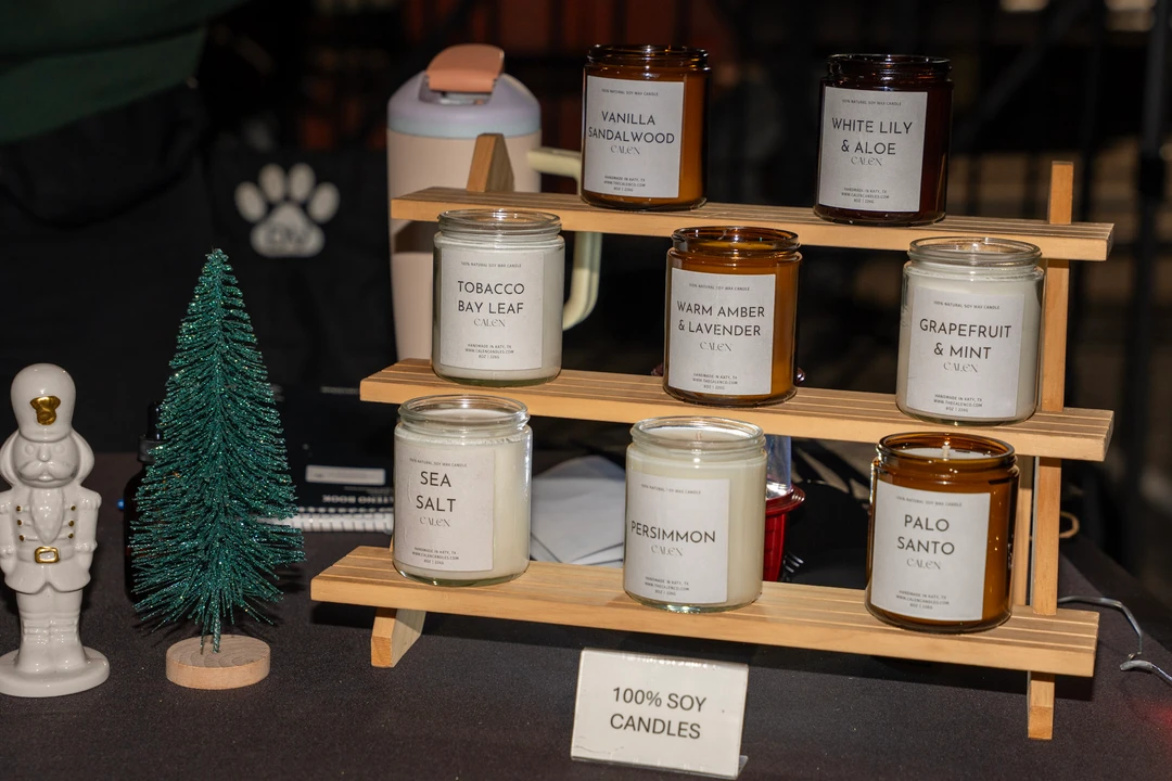 Candles and small festive decorations on wooden display shelves.