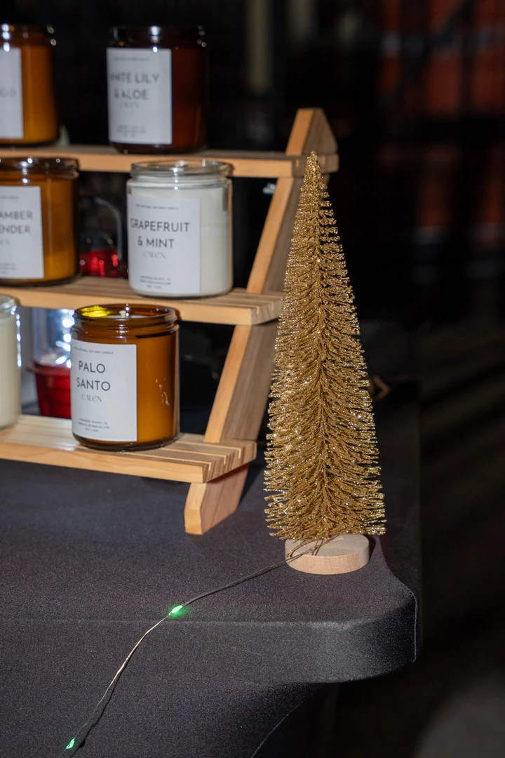 Candles and small festive decorations on wooden display shelves.