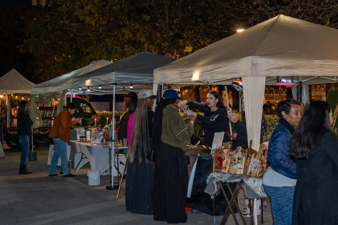Visitors walking through the illuminated evening market.