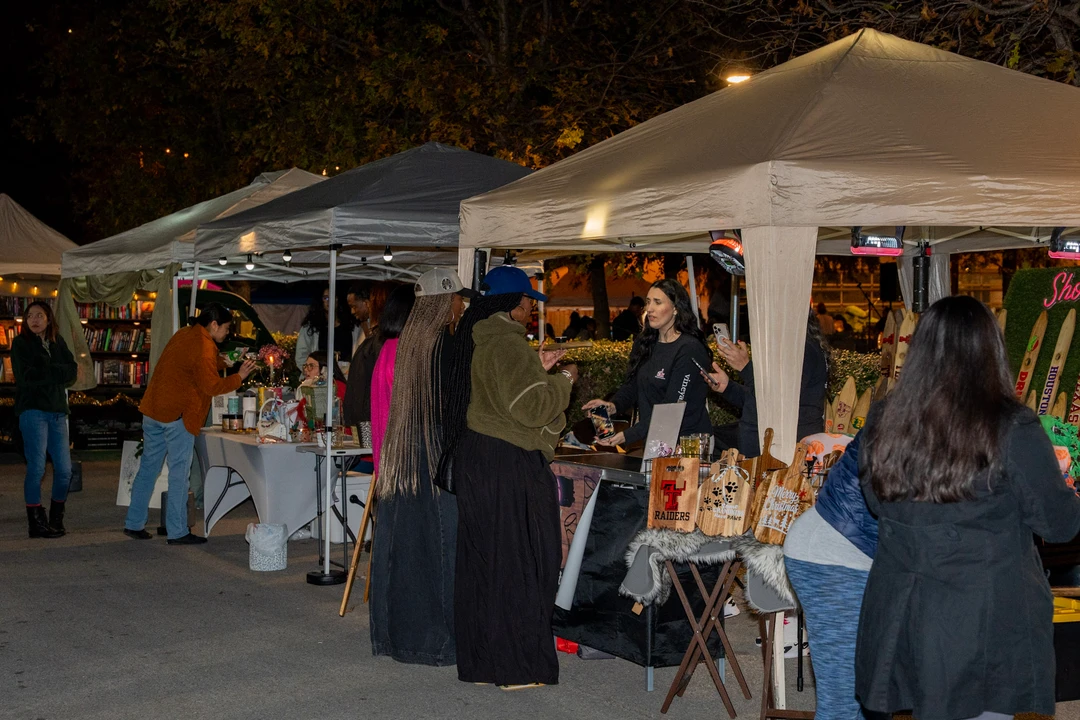 Visitors walking through the illuminated evening market.