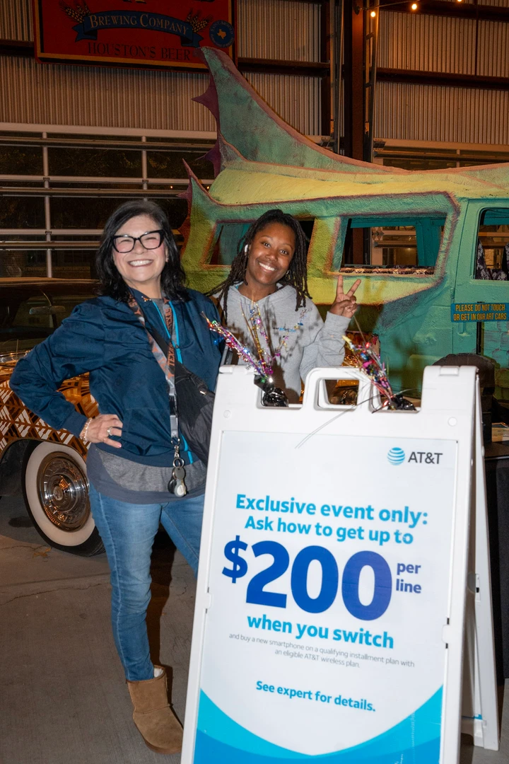 Two vendors posing beside an AT&T display.