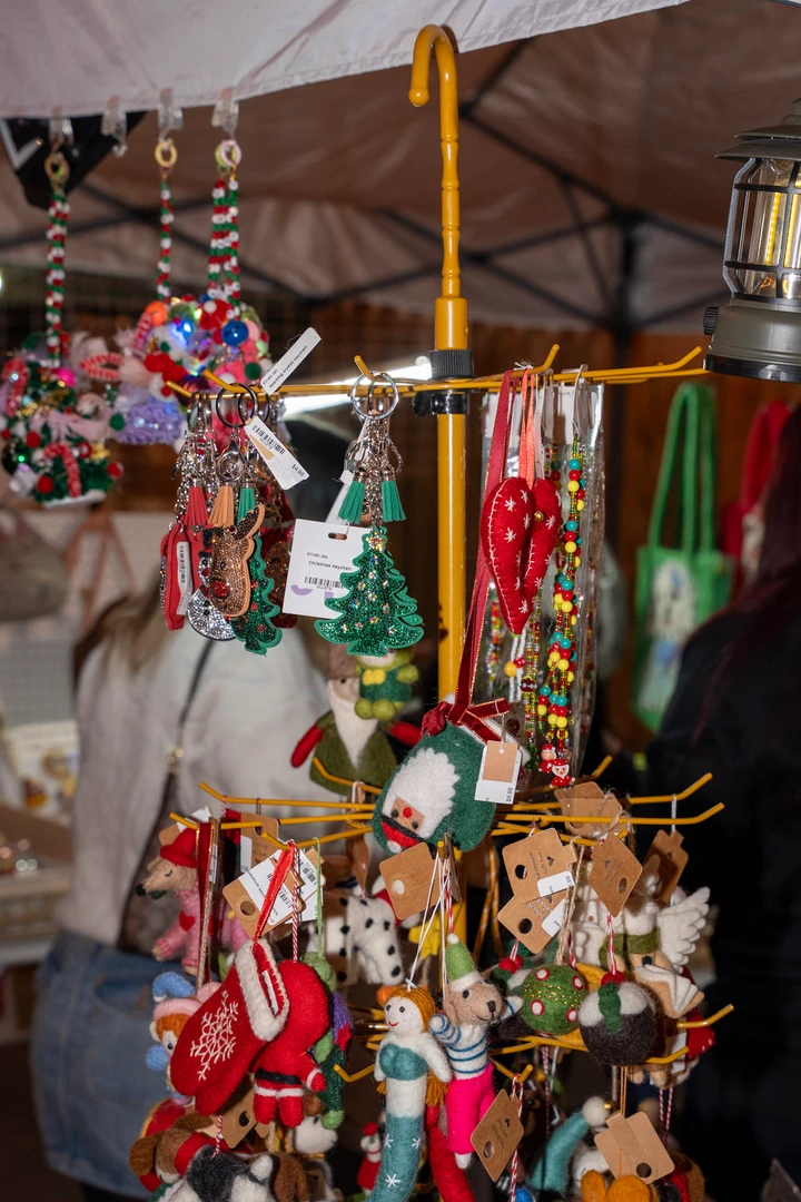 Hanging ornaments and colorful small gifts at a market stall.