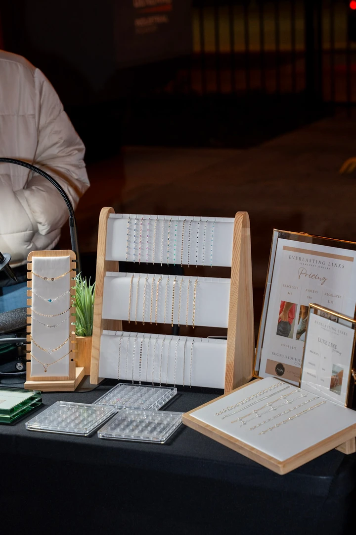 Necklaces and earrings arranged on pale display stands.