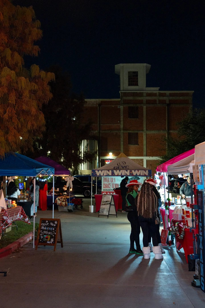 A walkway between illuminated market stalls at night.