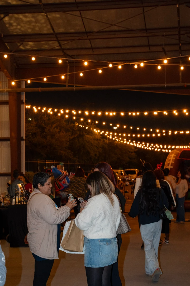 Visitors gathering beneath evening string lights.