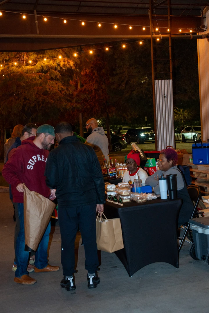 Visitors gathering beneath evening string lights.