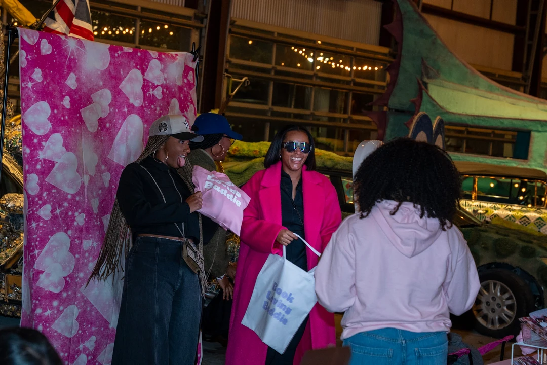 Makers and visitors at colorful indoor market stalls.
