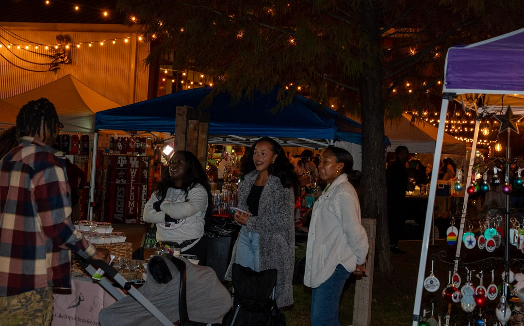 Friends gathering at an outdoor market table after dark.