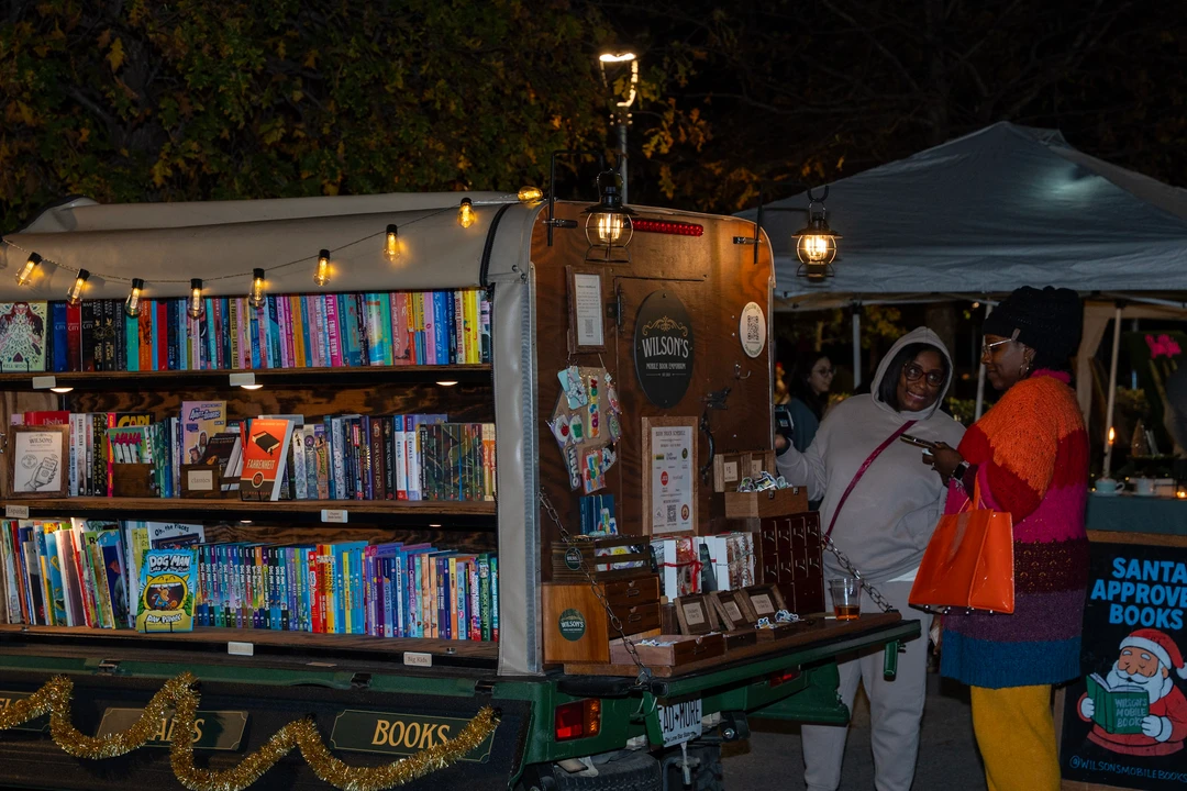 Visitors browsing the illuminated mobile bookshop.