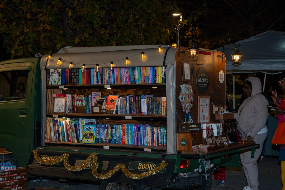 Visitors browsing the illuminated mobile bookshop.