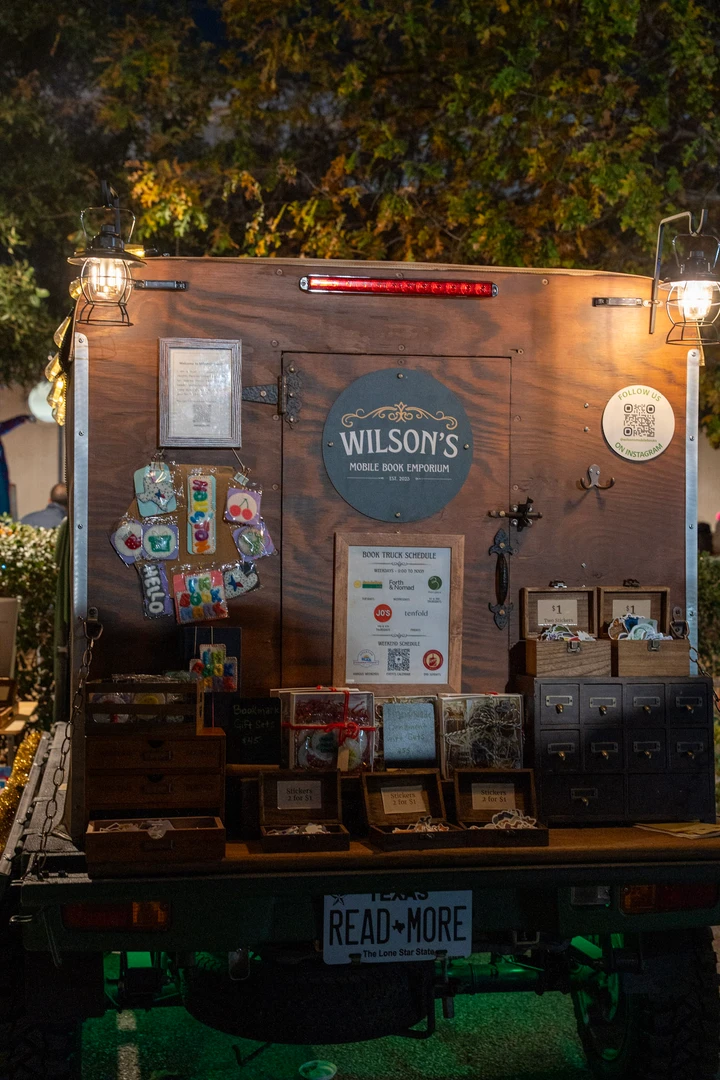 The mobile bookshop and its painted signs after dark.